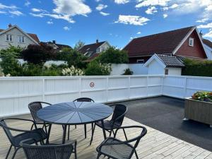 a patio with a table and chairs and a fence at Villa Hagevegen 3 A, Porsgrunn in Porsgrunn