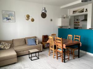 a living room with a couch and a table and chairs at Appartement à côté de la Gare in Hendaye