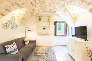 a living room with a couch and a tv at Italianway - Casa Leo in Ostuni