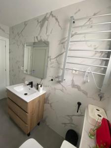 une salle de bain avec un lavabo et un miroir dans l'établissement Apartamento El Baluarte, à Cudillero 17 autres photos