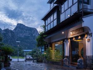a building with a view of mountains in the background at Guilin Qingshanshe Hotel -Free pick up train station stay two nights in Guilin