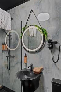 a bathroom with a black sink and a mirror at Gela's Terrace Apartment in Sibiu +29 photos