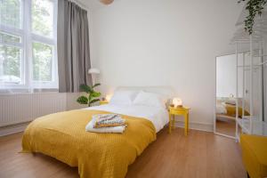 グレート・マルバーンにあるStylish apartment with parkingの白いベッドルーム(黄色い毛布付きのベッド付)