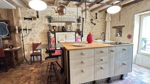 a kitchen with a island with a counter top at AU LIT ON DORT - Logis de Village in Bellême