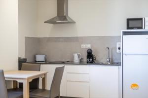 eine kleine Küche mit Tisch und Kühlschrank in der Unterkunft Delfin Azul by Cadiz Time in Cádiz + 27 Fotos
