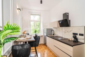a kitchen with a small table with chairs and a sink at HL Apartments in Maribor