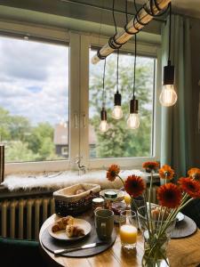 a table with food and flowers in front of a window at LIGHTQUARTIER Mountain Nest -Balkon in Sankt Andreasberg +10 photos