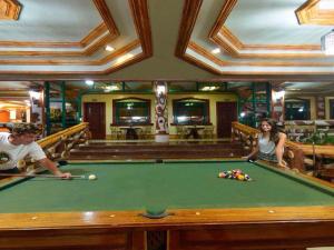 a man and a woman playing pool in a pool table at Big Creek Mansion in El Nido