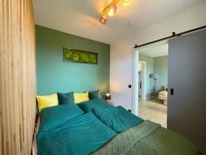 a bed in a bedroom with a green wall at LIGHTQUARTIER Mountain Nest -Balkon in Sankt Andreasberg
