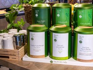 a group of green cans on a shelf at ibis Bordeaux Centre - Gare Saint-Jean in Bordeaux