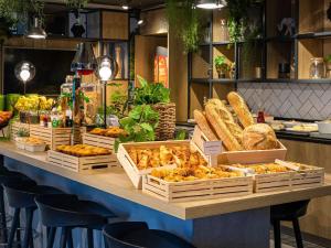 a display of bread and pastries on a counter in a store at ibis Bordeaux Centre - Gare Saint-Jean in Bordeaux