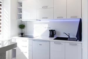 a kitchen with white cabinets and a sink at Studio apartment in Valmiera