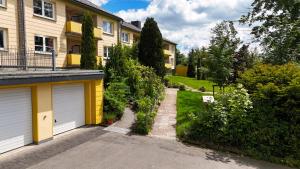a house with two garage doors and a driveway at LIGHTQUARTIER Mountain Nest -Balkon in Sankt Andreasberg