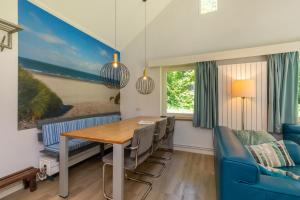 a dining room with a table and chairs and a bed at Fijne vakantiewoning bij strand Vrouwenpolder 'De Alk' in Vrouwenpolder