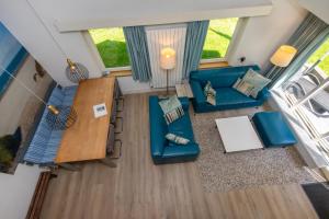 an overhead view of a living room with blue furniture at Fijne vakantiewoning bij strand Vrouwenpolder 'De Alk' in Vrouwenpolder