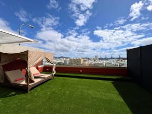 a canopy bed on the roof of a building with green grass at Panoramic Design Loft in Las Palmas de Gran Canaria +7 photos