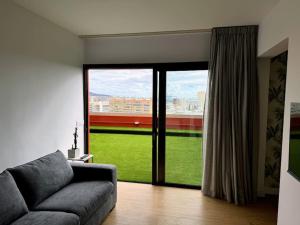 a living room with a couch and a large window at Panoramic Design Loft in Las Palmas de Gran Canaria
