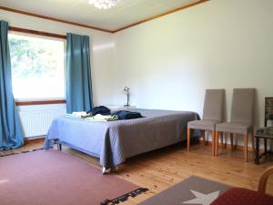 a bedroom with a bed with blue curtains and a window at Villa Siikakoski in Konnevesi