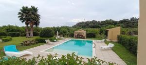 a swimming pool with chairs and a gazebo at Green House La Torre in Avola