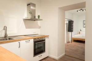 una cocina con fregadero y estufa horno superior en Spacious 1-Bedroom Apartment in Kreuzberg, en Berlín