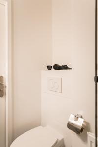 baño con aseo blanco y dispensador de papel higiénico en Spacious 1-Bedroom Apartment in Kreuzberg, en Berlín