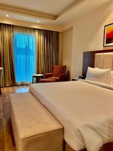 a hotel room with a large bed and a chair at Best Western Plus Amritsar in Amritsar