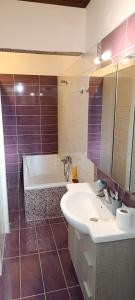 a bathroom with a tub and a sink and a mirror at Traditional two level Apartment in Liapades