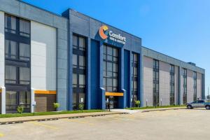 Un edificio con un coche aparcado en un estacionamiento. en Comfort Inn & Suites Evansville Airport, en Evansville