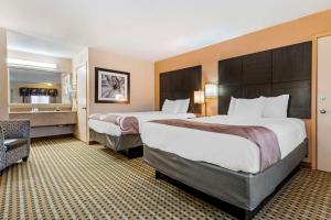 a hotel room with two beds and a chair at Quality Inn Amarillo West near Medical Center in Amarillo +46 photos