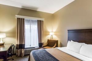 a hotel room with a bed and a desk and a window at Comfort Inn & Suites Cookeville in Cookeville