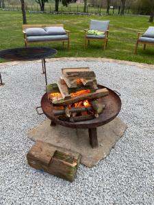 a fire pit in a yard with two chairs at Grudza83 Bikepoint in Mirsk