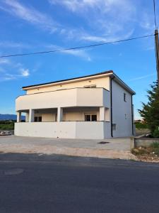 a white building on the side of a street at Apartmani Emanuel in Nin