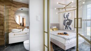 a bedroom with a bed and a bathroom with a mirror at ENKLAWA Apartamenty Piamola in Krynica Morska