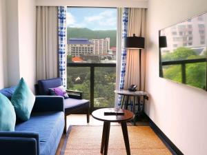 清迈Novotel Chiangmai Nimman Journeyhub的带沙发、桌子和窗户的客厅