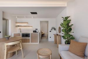 a living room and kitchen with a couch and a table at Morfes Luxury Suites by Caldera Houses in Firostefani