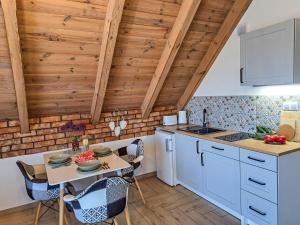 a kitchen with wooden ceilings and a table and chairs at 4 Pokoje Swory in Swornegacie