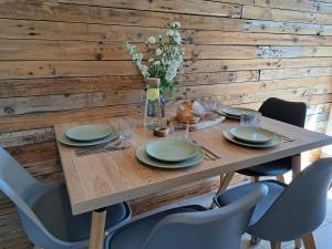 a wooden table with chairs and a wooden wall at 4 Pokoje Swory in Swornegacie +57 photos