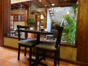 a table and two chairs in a room with a window at Siena Hotel in Cuenca