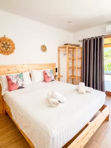a bedroom with a large white bed with pink pillows at Vraxlida Living in Himare