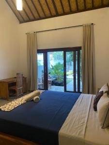 a bedroom with a large bed and a sliding glass door at Adore guesthouse in Amed +114 photos