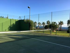 un filet de tennis sur un court de tennis avec l'océan en arrière-plan dans l'établissement Calas de Aguamarina Sea View - Holiday Home Cabo Roig, à Orihuela Costa