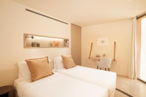 two white beds in a room with a desk at Palmares Signature Apartments in Lagos