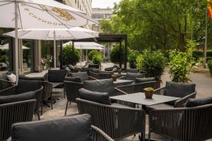 柏林DoubleTree by Hilton Berlin Ku'damm的有桌椅和遮阳伞的户外餐厅