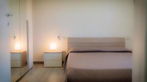 a bedroom with two beds and two lamps on night stands at Sardiniarooms Arbatax Beach in Àrbatax +14 photos