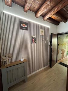 a hallway with a striped wall with a table and a door at Wood 32 family -jvapartmentRovigo in Rovigo