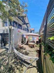 a wooden deck with a table and an umbrella at Maison de famille à 300m de la plage in Labenne