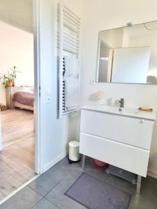 a bathroom with a sink and a mirror at Maison de famille à 300m de la plage in Labenne