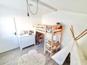 a child sleeping on a bunk bed in a room at Maison de famille à 300m de la plage in Labenne
