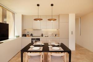 a kitchen with a black table and chairs in a room at Palmares Signature Apartments in Lagos