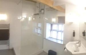 a white bathroom with a sink and a shower at Sparks - Turnbridge Guest House in Burnley